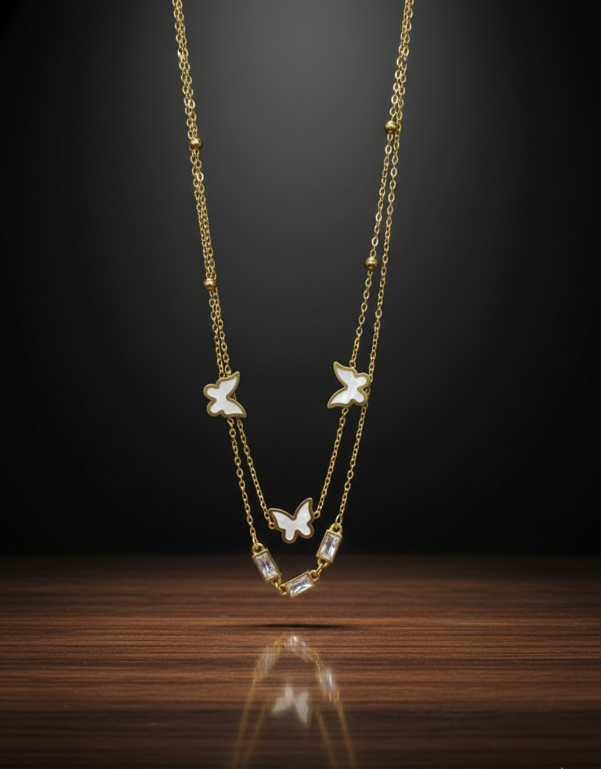 Gold necklace with butterfly pendants on a dark background