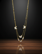 Gold necklace with butterfly pendants on a dark background