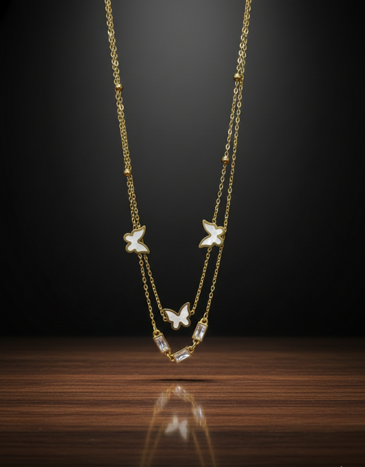 Gold necklace with butterfly pendants on a dark background