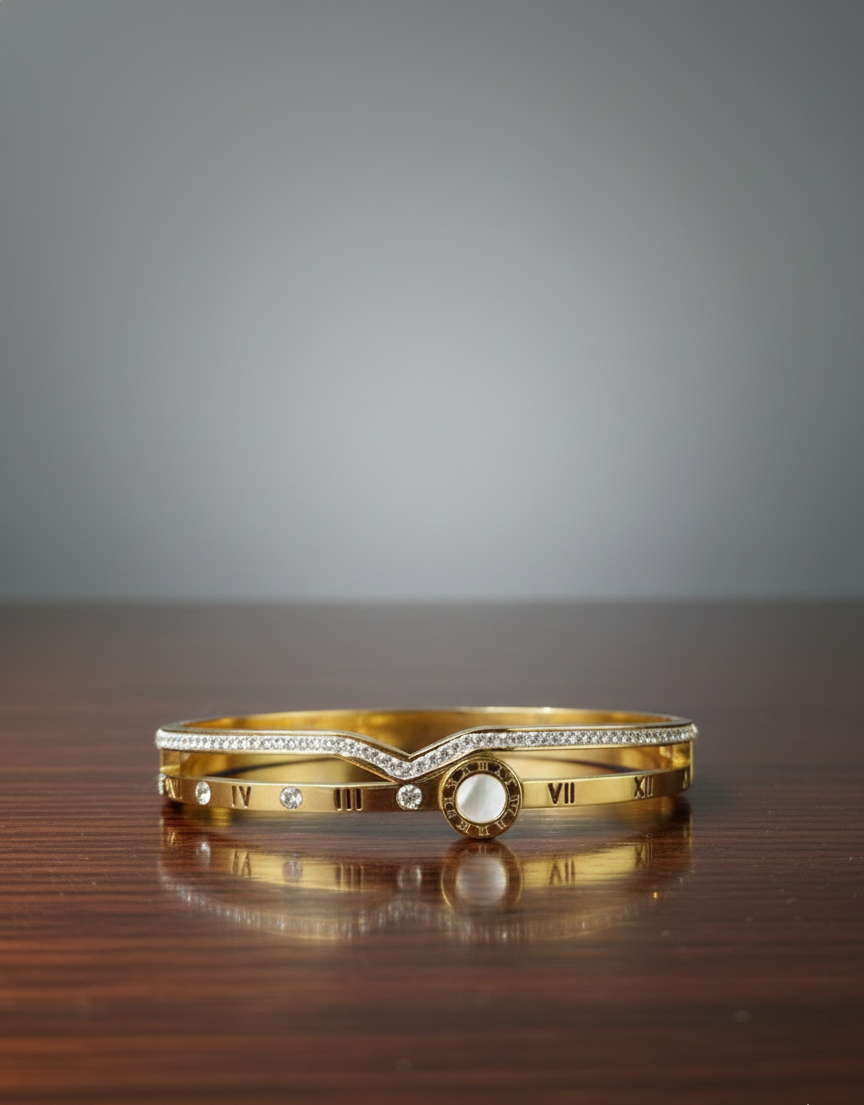 Gold bracelet with embedded stones on a wooden surface and gray background