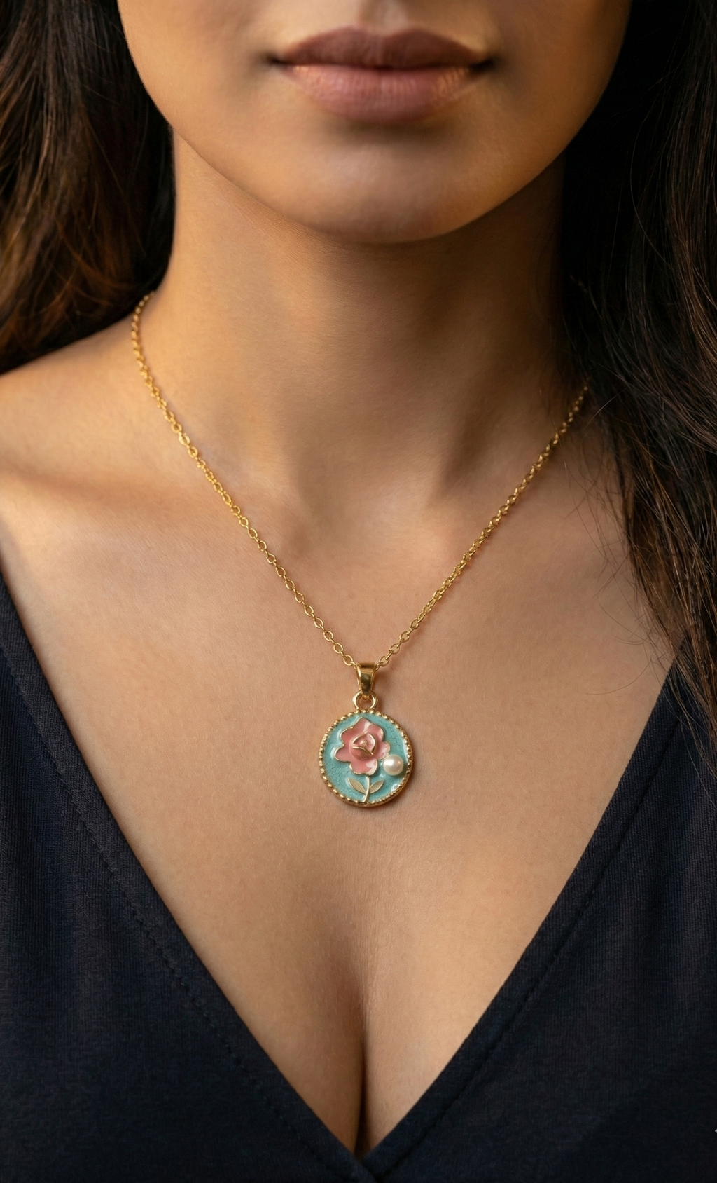 Necklace with a pendant featuring a rose design worn by a person in a black top.