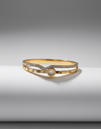 Gold bracelet with a central gemstone on a gray background