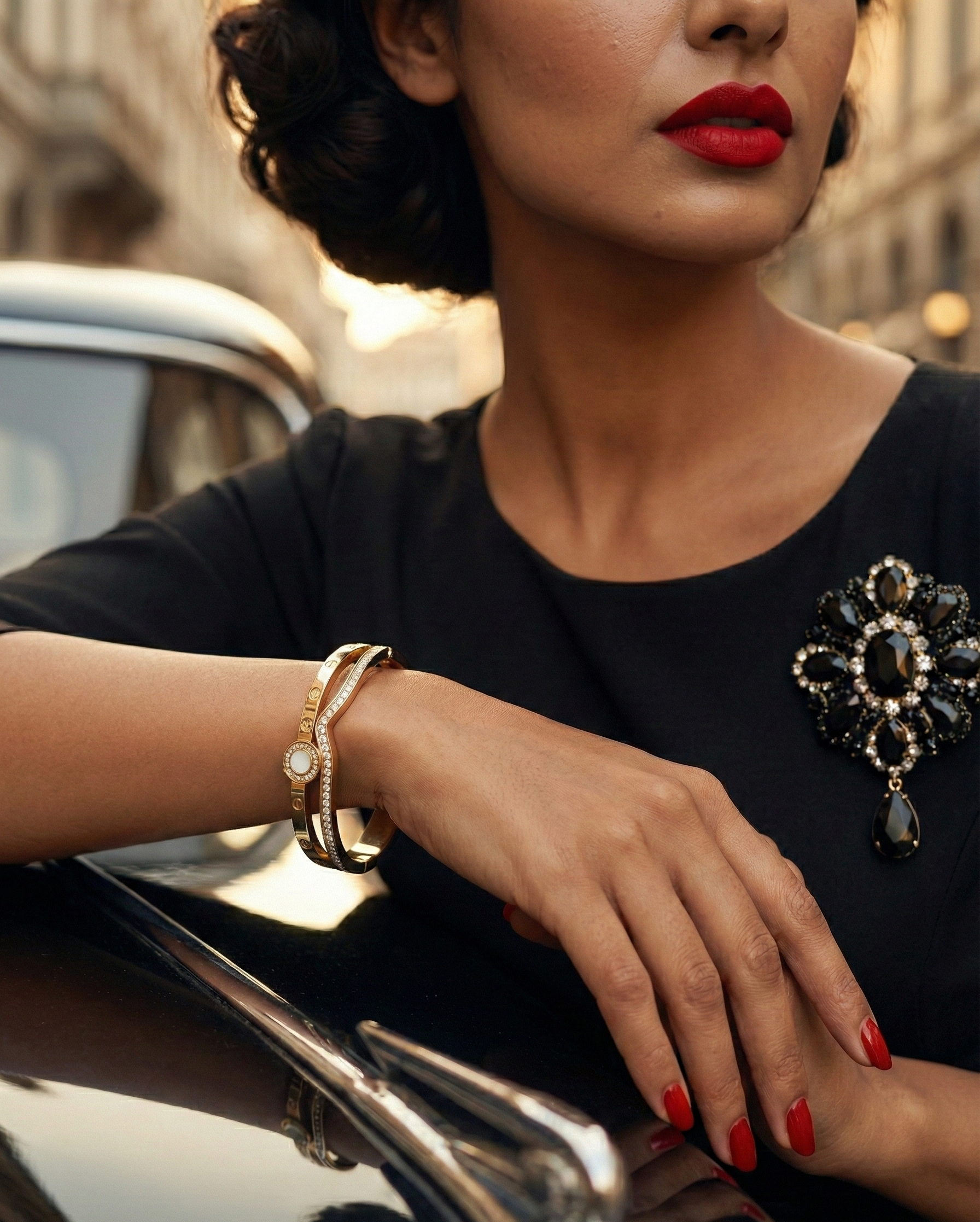 Woman with red lipstick and jewelry leaning on a car in an urban setting
