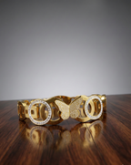 Gold bracelet with butterfly design on a wooden surface