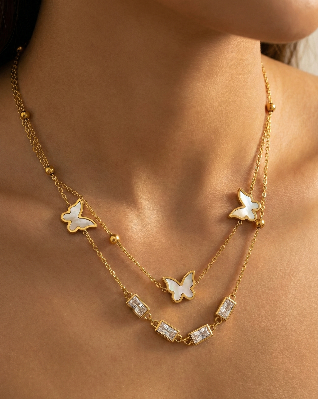 Gold butterfly necklace on a person's neck