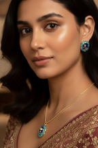 Woman wearing a gold necklace and earrings with a blurred background