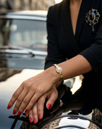 Person wearing a gold bracelet on a car, with a blurred background